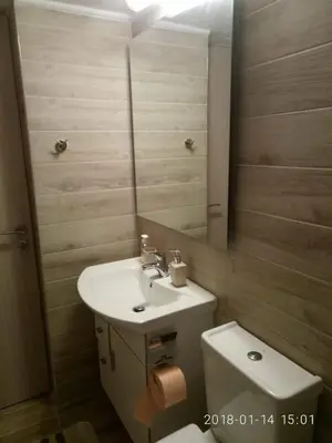 a bathroom with a sink and a toilet and a mirror at Modern, ideally located studio apartment in Athens