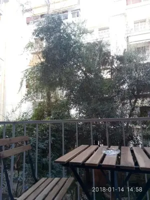 a wooden picnic table sitting next to a fence at Modern, ideally located studio apartment in Athens