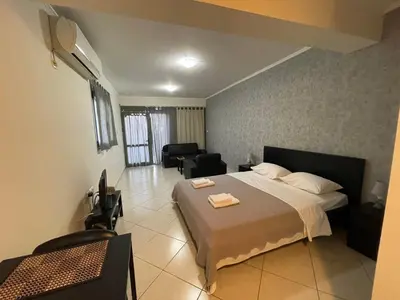 a bedroom with a bed and a living room at AVR Airport Deluxe Suites 4 AIRPORT FREE SHUTLE in Markopoulo