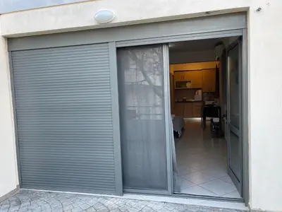 a sliding garage door with a view of a room at AVR Airport Deluxe Suites 4 AIRPORT FREE SHUTLE in Markopoulo