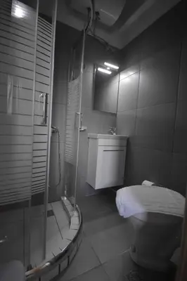 a bathroom with a shower and a toilet and a sink at AVR Airport Deluxe Suites 4 AIRPORT FREE SHUTLE in Markopoulo