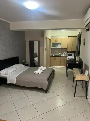 a bedroom with a large bed and a kitchen at AVR Airport Deluxe Suites 4 AIRPORT FREE SHUTLE in Markopoulo
