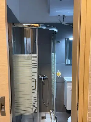 a shower with a glass door in a bathroom at AVR Airport Deluxe Suites 4 AIRPORT FREE SHUTLE in Markopoulo