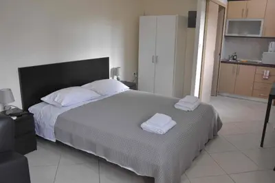 a bedroom with a large bed with two towels on it at AVR Airport Deluxe Suites 4 AIRPORT FREE SHUTLE in Markopoulo