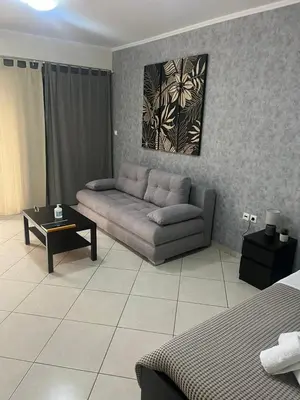 a living room with a couch and a table at AVR Airport Deluxe Suites 4 AIRPORT FREE SHUTLE in Markopoulo