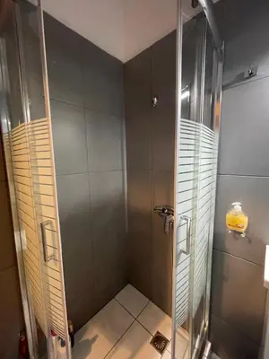 a shower with a glass door in a bathroom at AVR Airport Deluxe Suites 4 AIRPORT FREE SHUTLE in Markopoulo