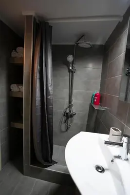 a bathroom with a white sink and a shower at COZY APT NEXT TO METRO AND CLOSE TO ACROPOLIS! in Athens