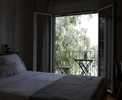 a bedroom with a bed and a balcony with a view at COZY APT NEXT TO METRO AND CLOSE TO ACROPOLIS! in Athens