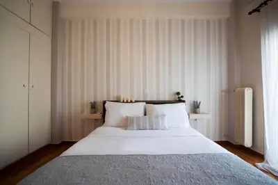 a bedroom with a large white bed with white pillows at COZY APT NEXT TO METRO AND CLOSE TO ACROPOLIS! in Athens
