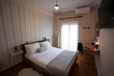 a bedroom with a large white bed and a desk at COZY APT NEXT TO METRO AND CLOSE TO ACROPOLIS! in Athens