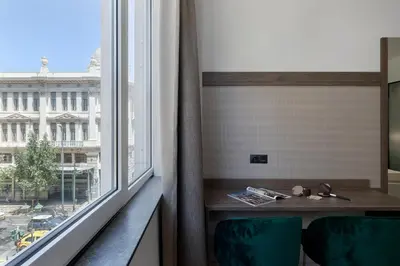 a room with a window with a table and chairs at Philosofia Athens Suites in Athens