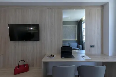 a room with a desk with a laptop and a red bag at Philosofia Athens Suites in Athens