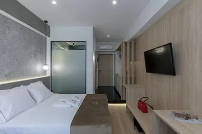a hotel room with a bed and a television at Philosofia Athens Suites in Athens