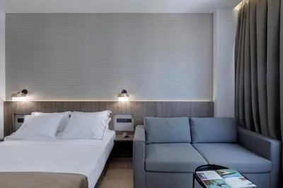 a hotel room with a bed and a couch at Philosofia Athens Suites in Athens
