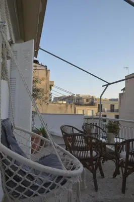 a hammock on a balcony with tables and chairs at Mosaics Central aprtm with Acropolis View ! in Athens