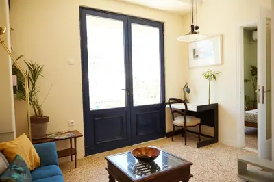 a living room with a black door and a table at Mosaics Central aprtm with Acropolis View ! in Athens