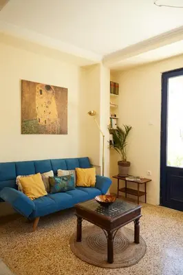 a living room with a blue couch and a table at Mosaics Central aprtm with Acropolis View ! in Athens