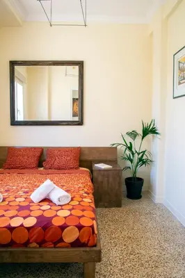 a bedroom with a bed with a mirror and a plant at Mosaics Central aprtm with Acropolis View ! in Athens