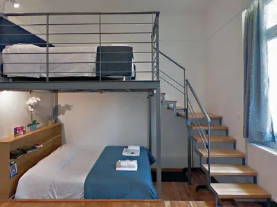a bedroom with a bunk bed and a staircase at Neoclassical House with Unique Athenian Yard (nearby metro station) in Athens