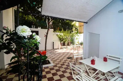 a patio with a table and chairs and flowers at Neoclassical House with Unique Athenian Yard (nearby metro station) in Athens