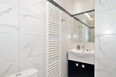 a white bathroom with a sink and a toilet at Neoclassical House with Unique Athenian Yard (nearby metro station) in Athens