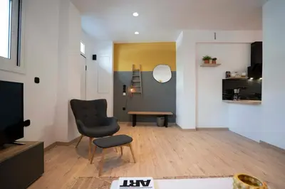 a living room with a chair and a television at Modern 2bed 2bath loft in Acropolis area in Athens