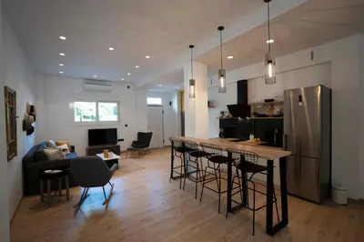 a kitchen and living room with a bar with stools at Modern 2bed 2bath loft in Acropolis area in Athens