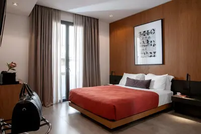 a hotel room with a large bed and a window at The Editor Hotel Athens in Athens