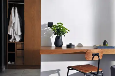 a wooden desk with a vase with a plant on it at The Editor Hotel Athens in Athens