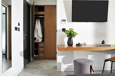 a living room with a desk and a tv on a wall at The Editor Hotel Athens in Athens