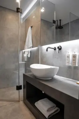 a bathroom with a sink and a glass shower at The Editor Hotel Athens in Athens