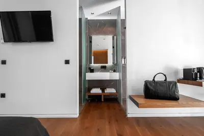 a room with a mirror and a bag on a wooden floor at The Editor Hotel Athens in Athens