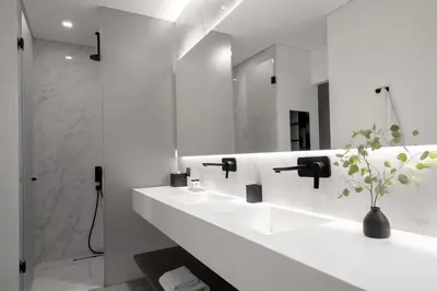 a white bathroom with two sinks and a mirror at The Editor Hotel Athens in Athens