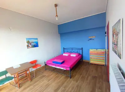 a room with a pink bed and a table at SleepEasy City center in Athens