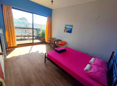 a bedroom with a pink bed and a large window at SleepEasy City center in Athens