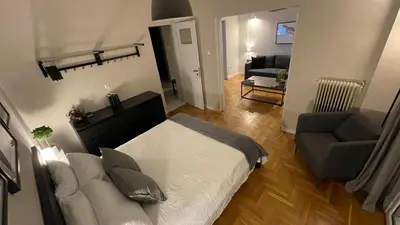 a bedroom with a bed and a couch and a chair at 2 Newly Renovated Charming Apartments steps from Panormou Metro Station in Athens