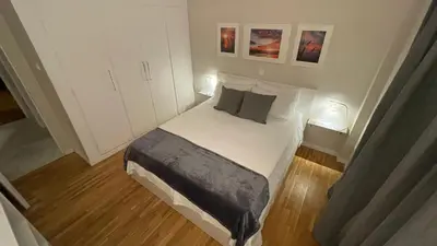 a small bedroom with a bed and two pictures on the wall at 2 Newly Renovated Charming Apartments steps from Panormou Metro Station in Athens