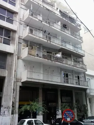 an apartment building with balconies and cars parked in front of it at Omonia Square Apartment in Athens