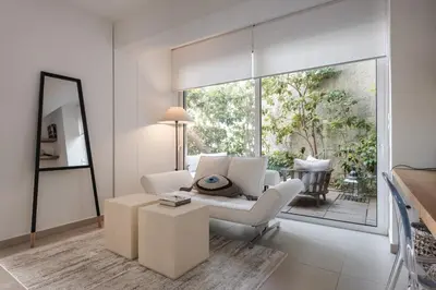 a living room with white furniture and a large window at Bliss Living in Vouliagmeni