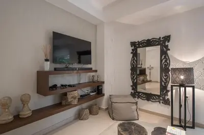 a living room with a mirror and a chair at Bliss Living in Vouliagmeni