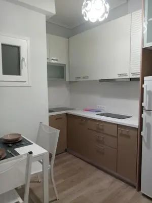a kitchen with a table and a white refrigerator at Studio NATASHA without PARKING in Athens