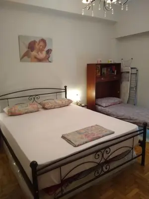 a bedroom with two beds and a painting on the wall at Acropolis within 10min. walk! in Athens