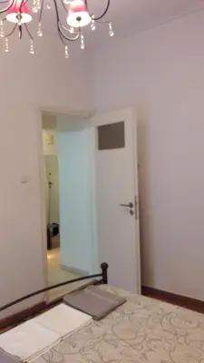 a bedroom with a mirror and a bed and a chandelier at Acropolis within 10min. walk! in Athens