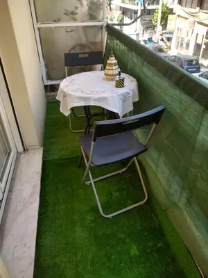 a table and chairs on a balcony with green grass at Acropolis within 10min. walk! in Athens