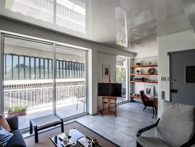 a living room with a tv and a large window at Peripatos apartment in Athens