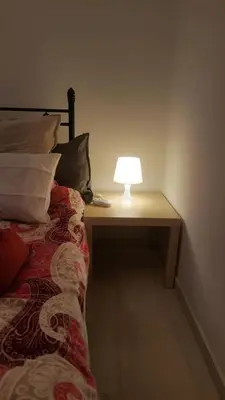 a lamp sitting on a table next to a bed at Apartment by Sepolia Metro-Ησυχη γκαρσονιερα κοντα στο Μετρό in Athens