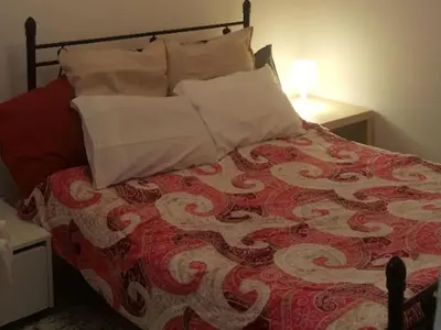 a bed with a red and white comforter and pillows at Apartment by Sepolia Metro-Ησυχη γκαρσονιερα κοντα στο Μετρό in Athens