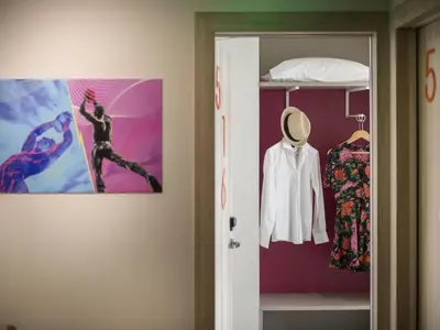 a room with a closet with a poster on the wall at ibis Styles Athens Routes in Athens