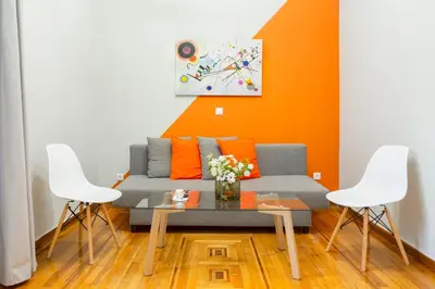 a living room with a couch and two chairs at Acropolis Apartments in Athens