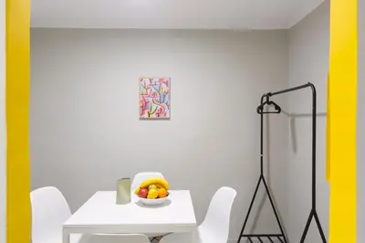 a white table and chairs with a bowl of fruit on it at Acropolis Apartments in Athens